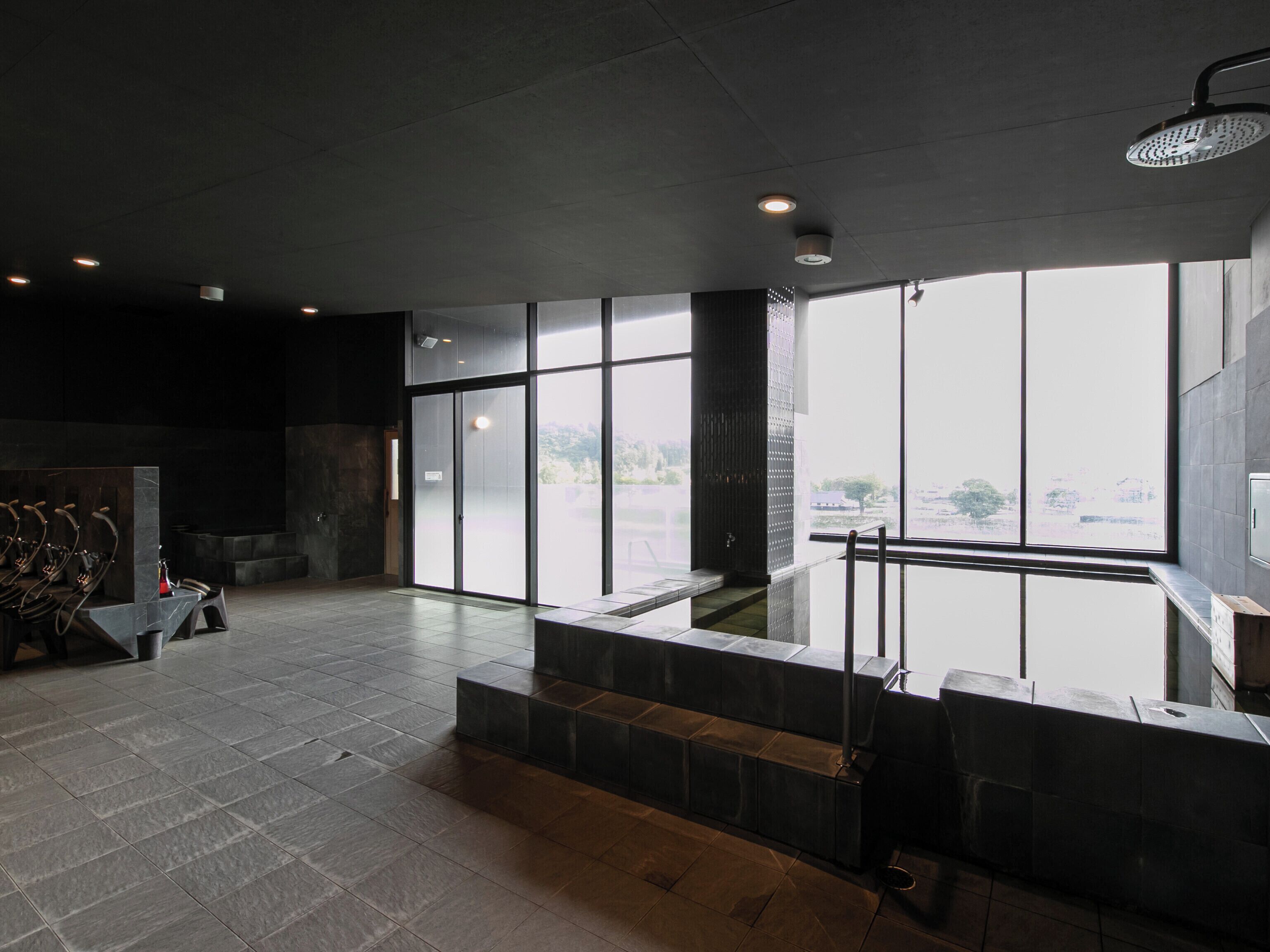 A modern indoor space with a large window, a seating area, and a water feature.
