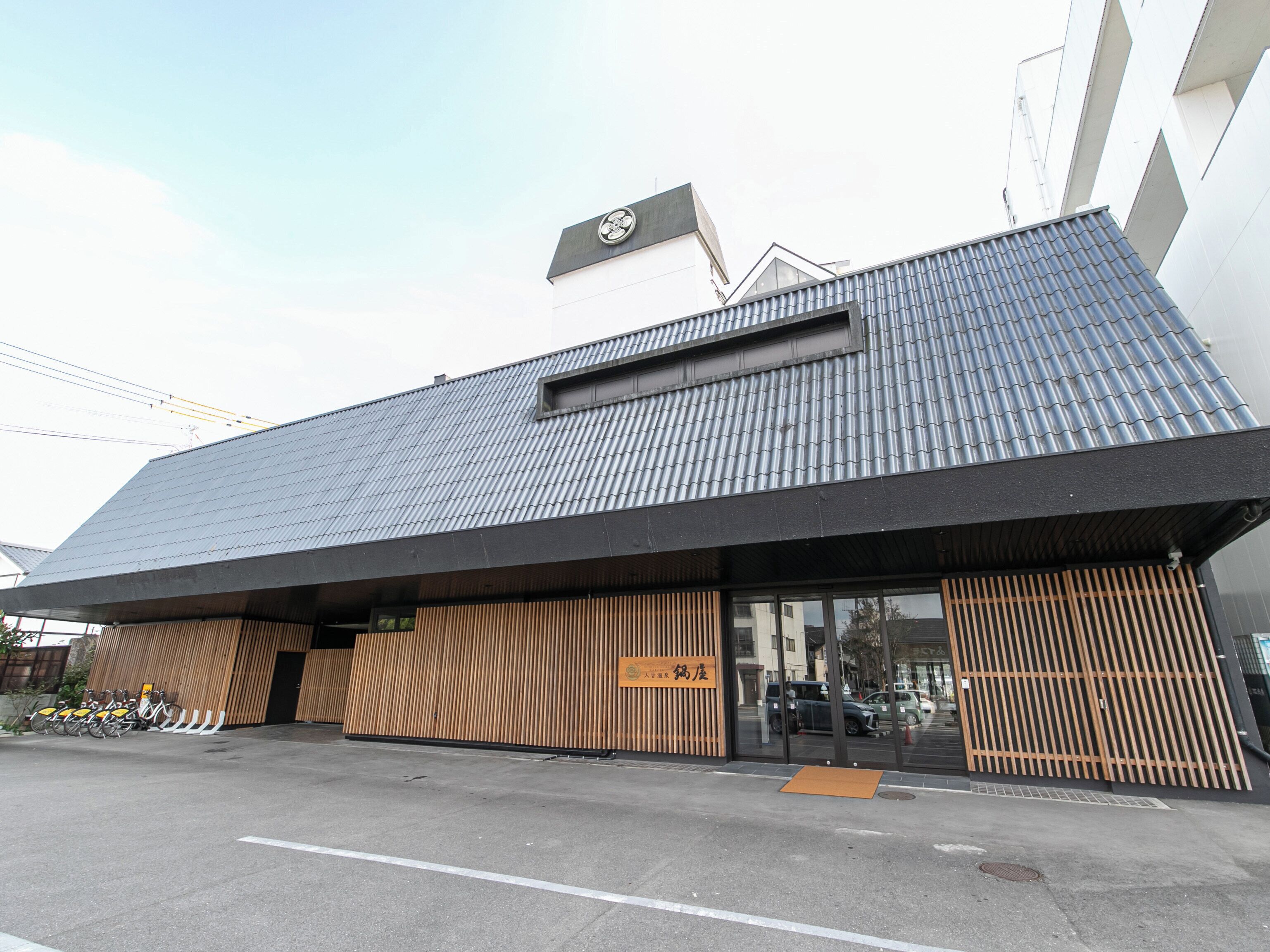 A modern building with a sloped roof and a sign indicating it is a restaurant.