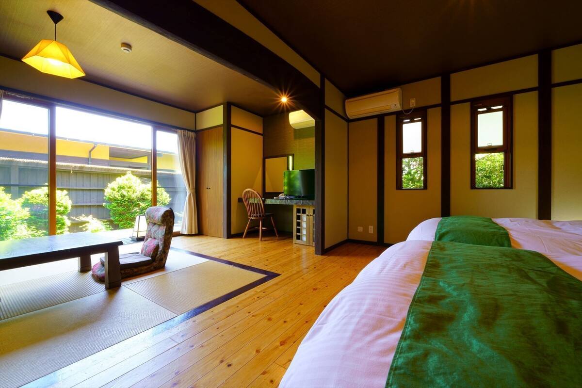 A room with a bed, a desk, a chair, and a television.