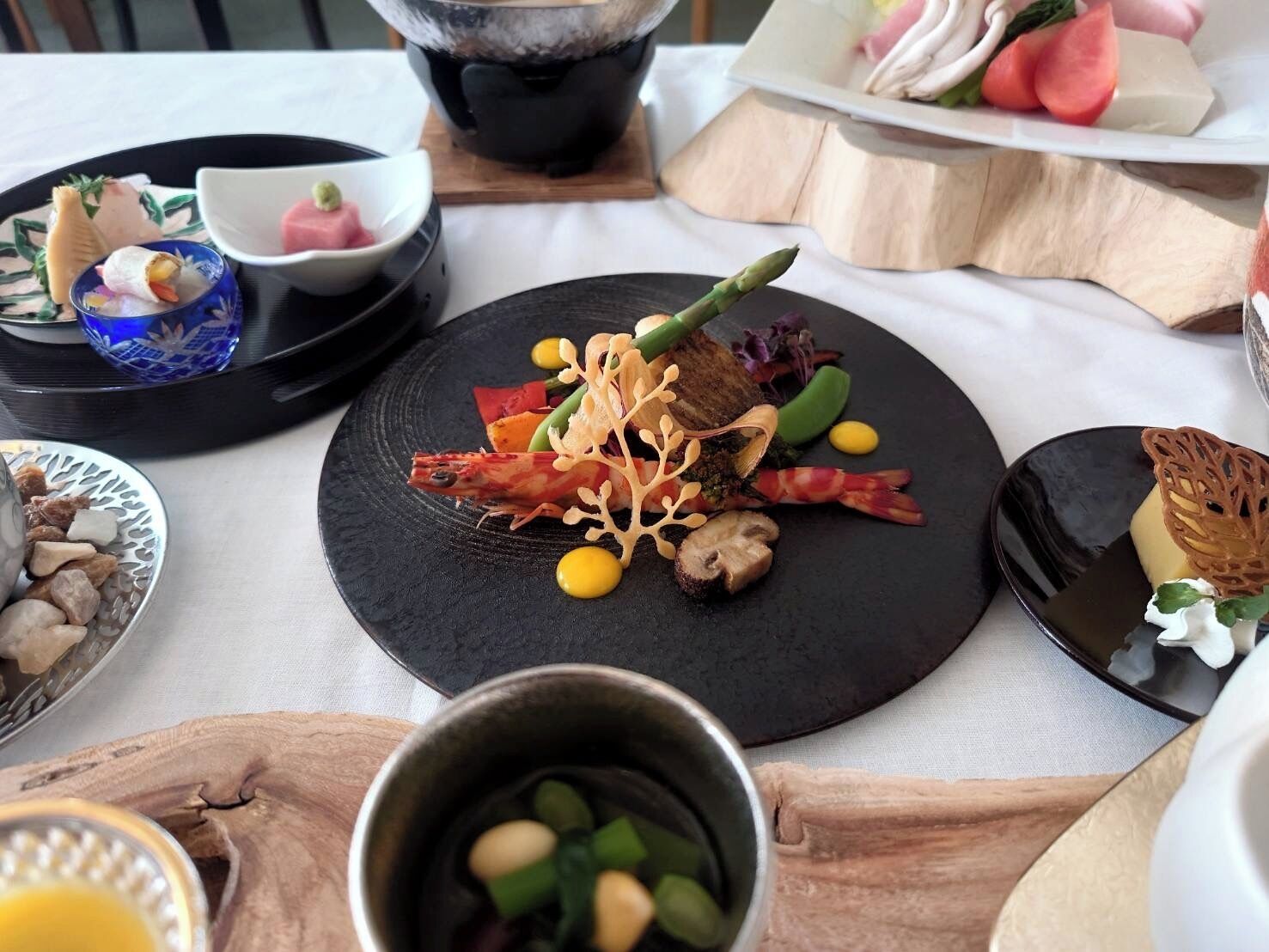 A dining table with various dishes, including seafood, vegetables, and a dessert.