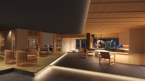 Un interior moderno con una zona de estar central, separadores de madera y vistas a un jardín.