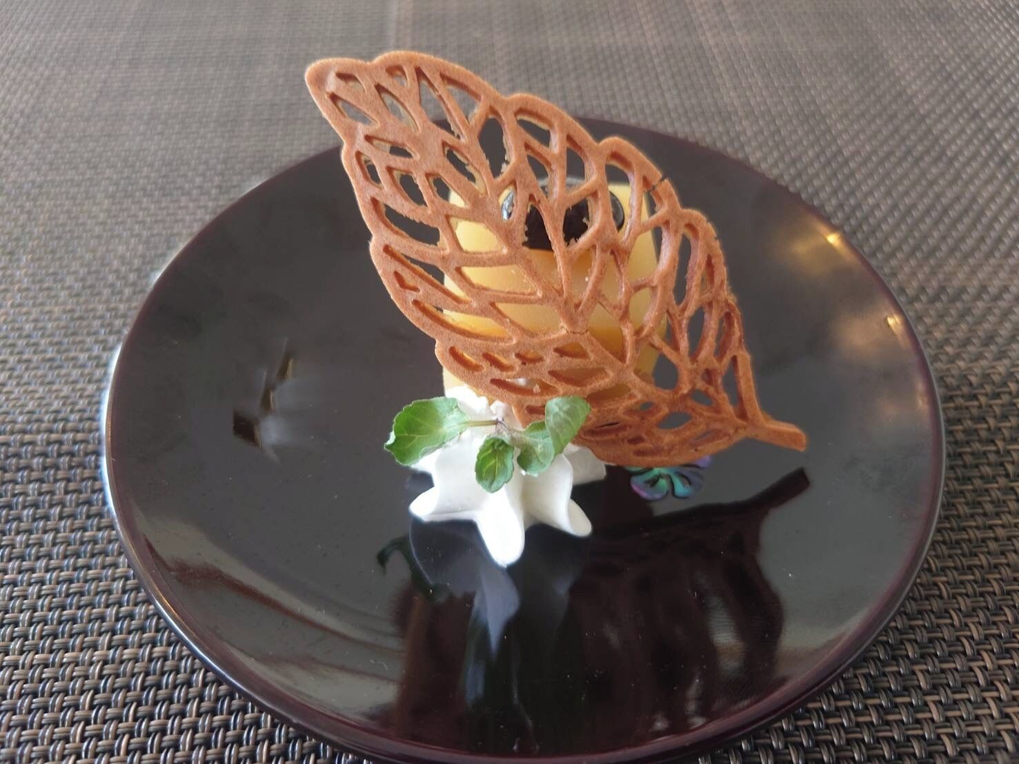 A decorative item on a dark plate with a woven texture background.