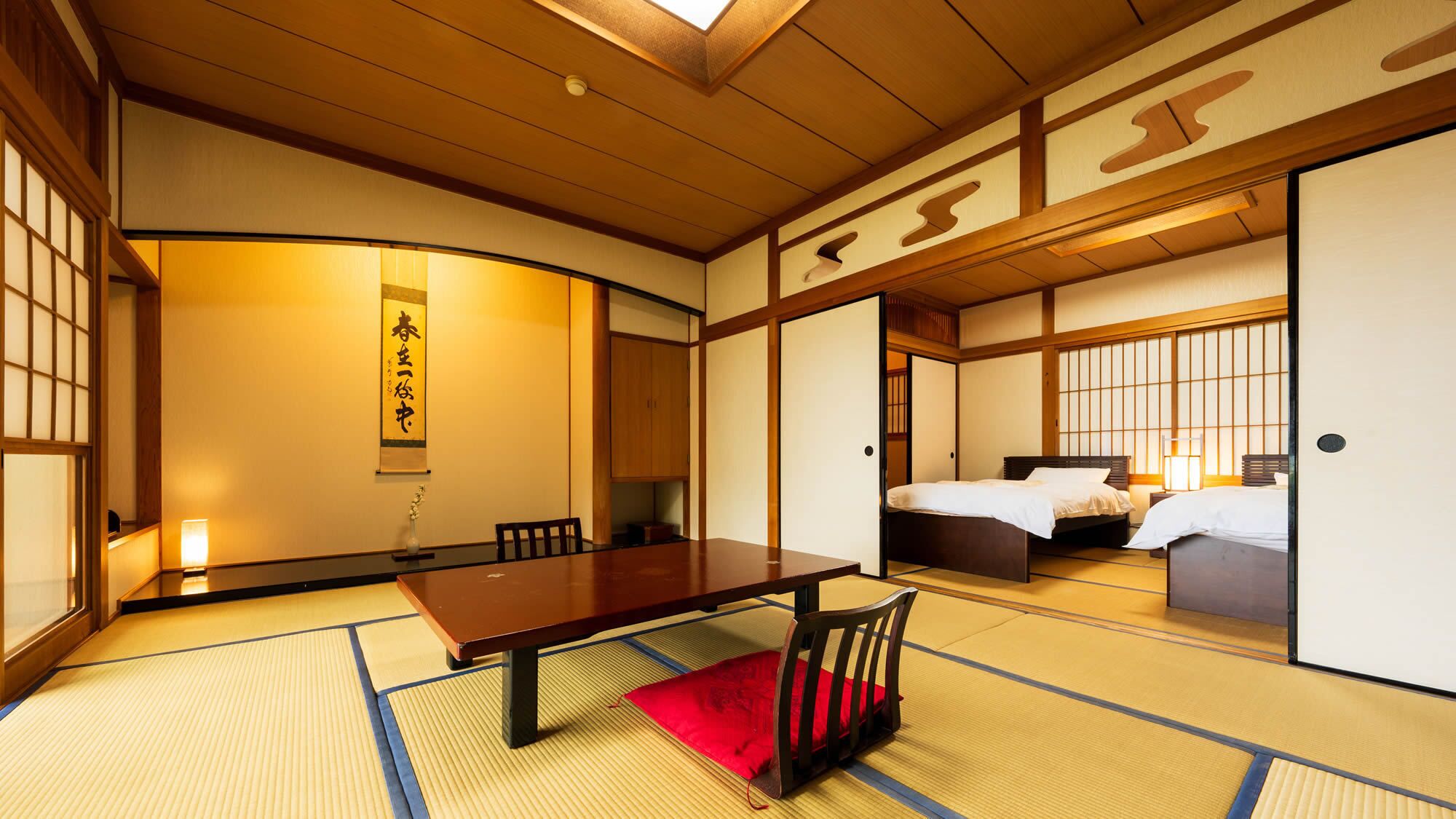 A traditional Japanese room with tatami flooring, a wooden table, a bed, and sliding doors.