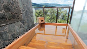 A stone wall, a wooden deck, and a view of a lake and mountains. - Hotel Manyomisaki (Aioi)