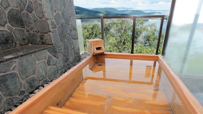 A stone wall, a wooden deck, and a view of a lake and mountains. - Hotel Manyomisaki (Aioi)