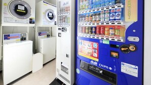 A laundromat with a vending machine selling beverages and snacks. - Urban Hotel Tokyo Fuchu Nisiguchi (Fuchu)