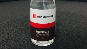 A spray bottle with a label, placed on a dark surface.