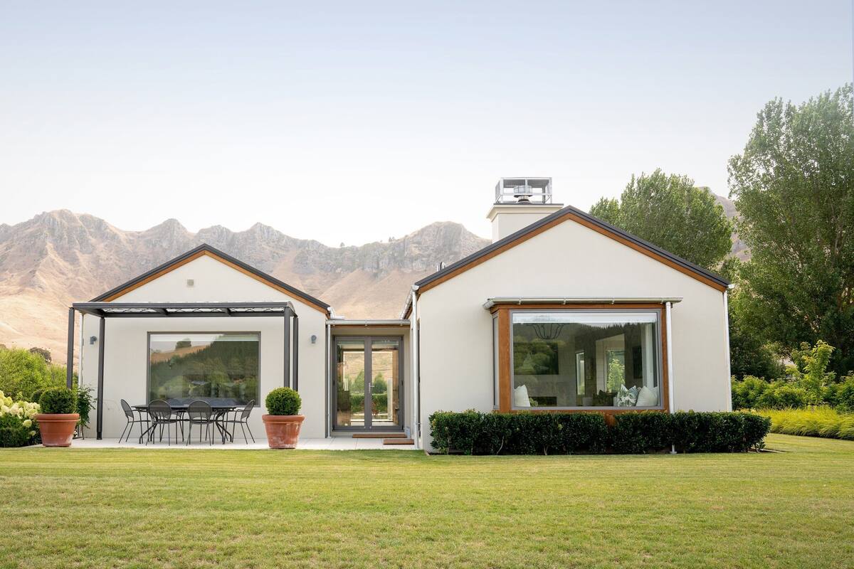 A modern house with a patio, a dining area, and a large window.