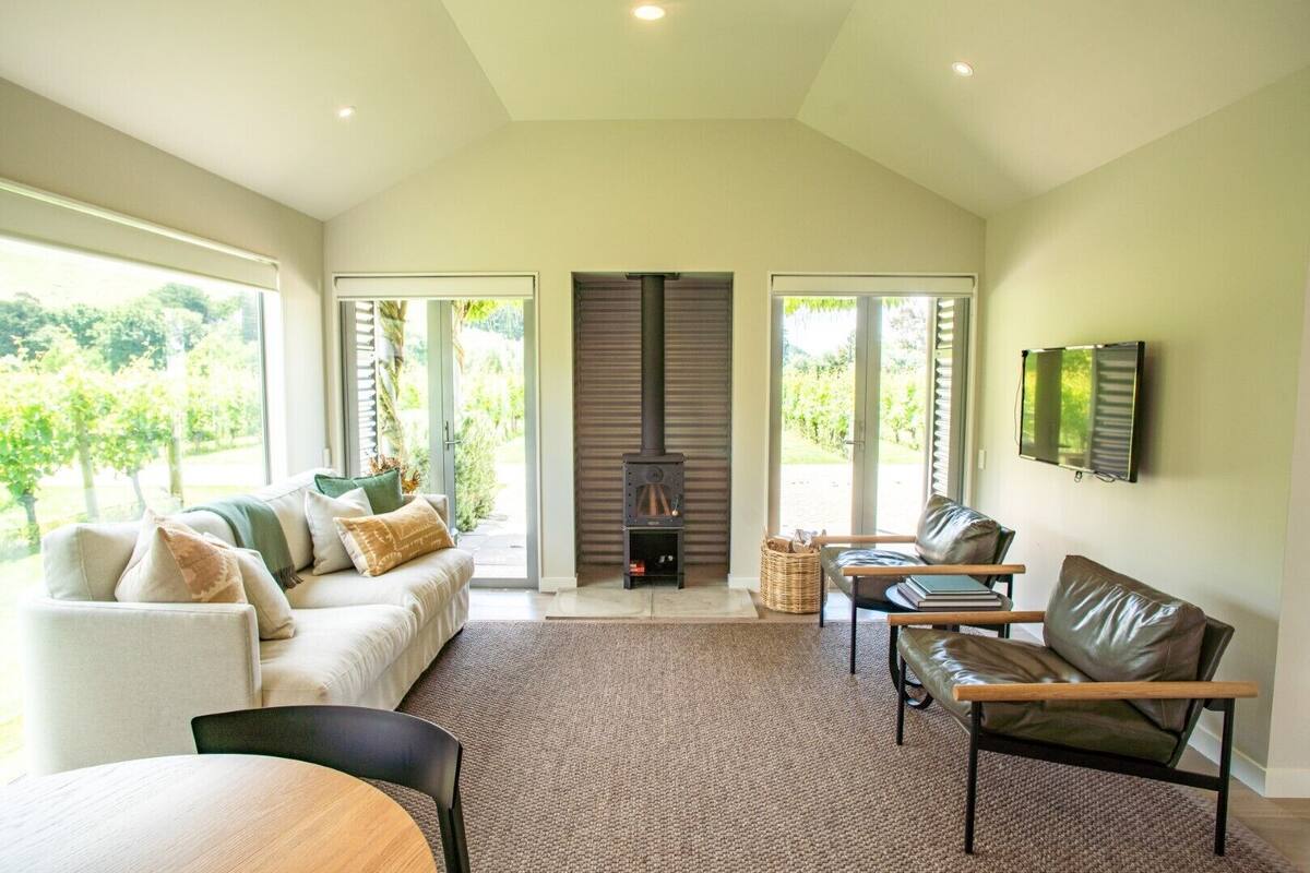 A spacious living room with a fireplace, large windows, and a comfortable seating area.