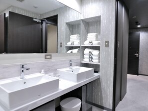 Une salle de bain moderne avec deux lavabos, un miroir et un porte-serviettes avec des serviettes.