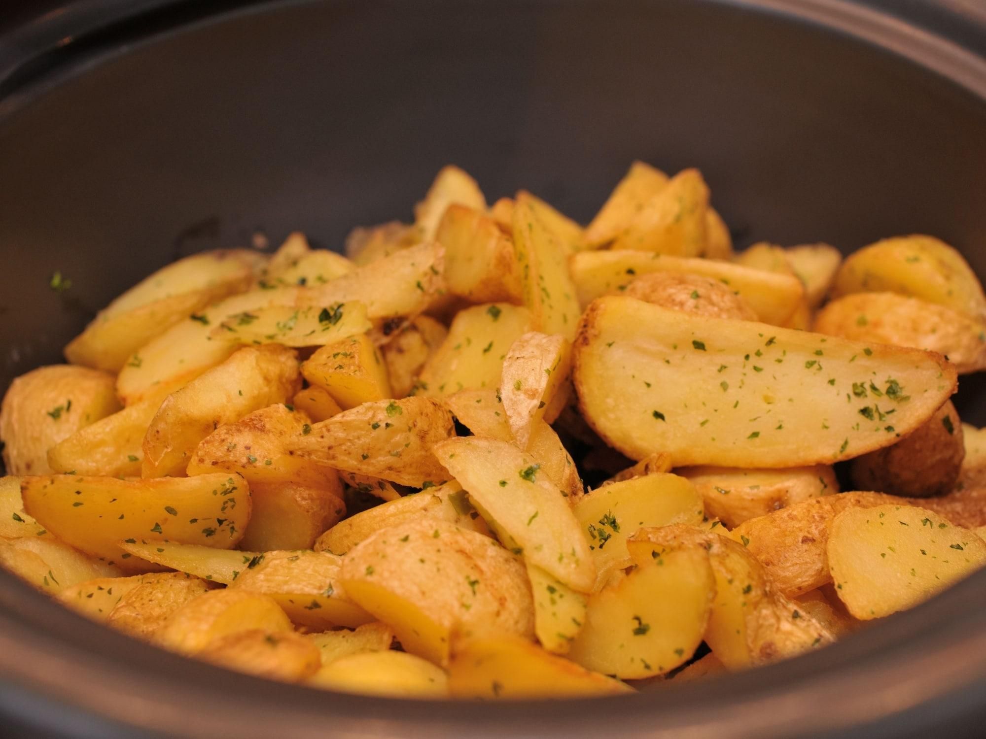 A close-up of roasted potatoes seasoned with herbs.