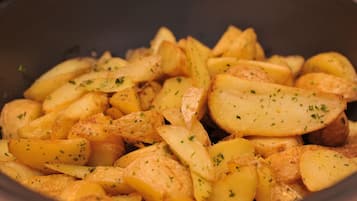 A close-up of roasted potatoes seasoned with herbs.