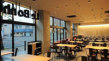 A restaurant with large windows, multiple tables, and chairs.