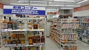 Passís d'una botiga de licors, amb diverses ampolles d'alcohol i un cartell que indica la necessitat de verificar l'edat legal.