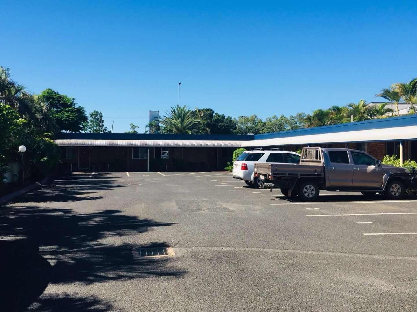 Ein Parkplatz mit einem Gebäude im Hintergrund.