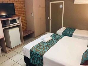 A hotel room with two beds, a TV, a microwave, and a small fridge.