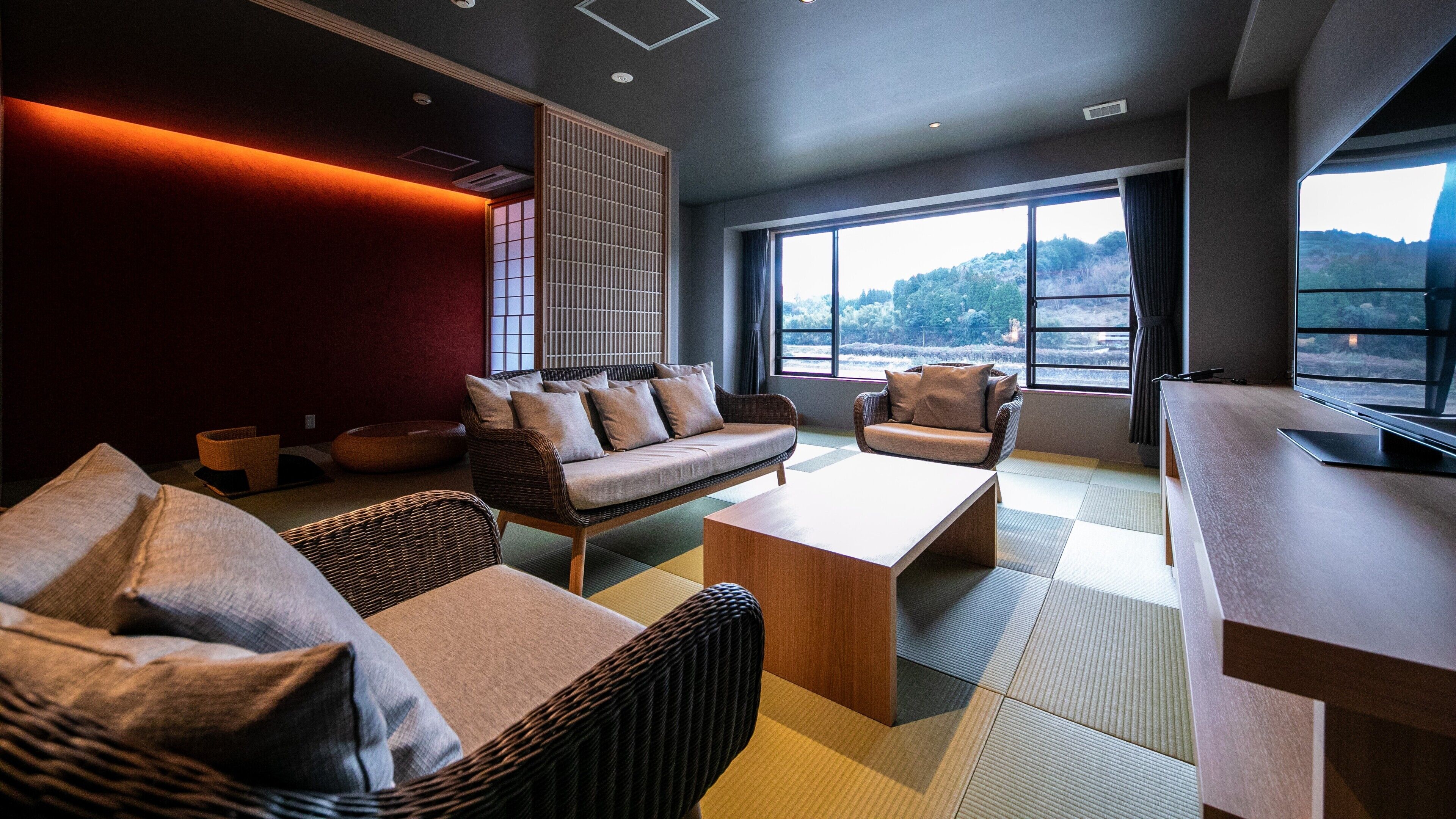 Una sala de estar moderna con un sofá, sillones, una mesita de centro y un amplio ventanal con vistas.