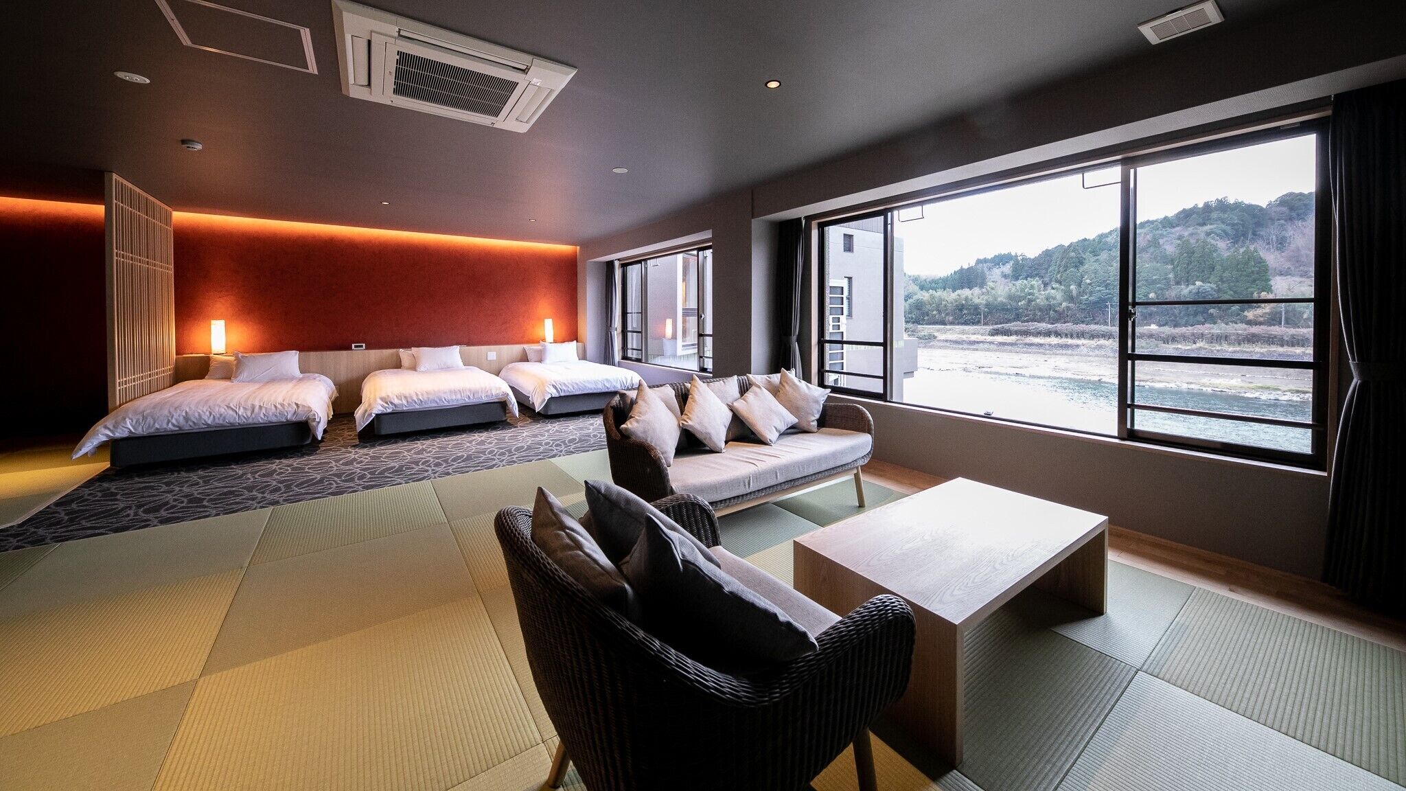 Habitación de hotel con cama, sofá y vista al mar.