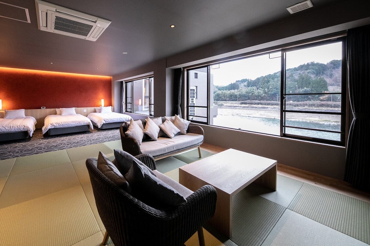 Habitación de hotel con cama, sofá y vista al mar.