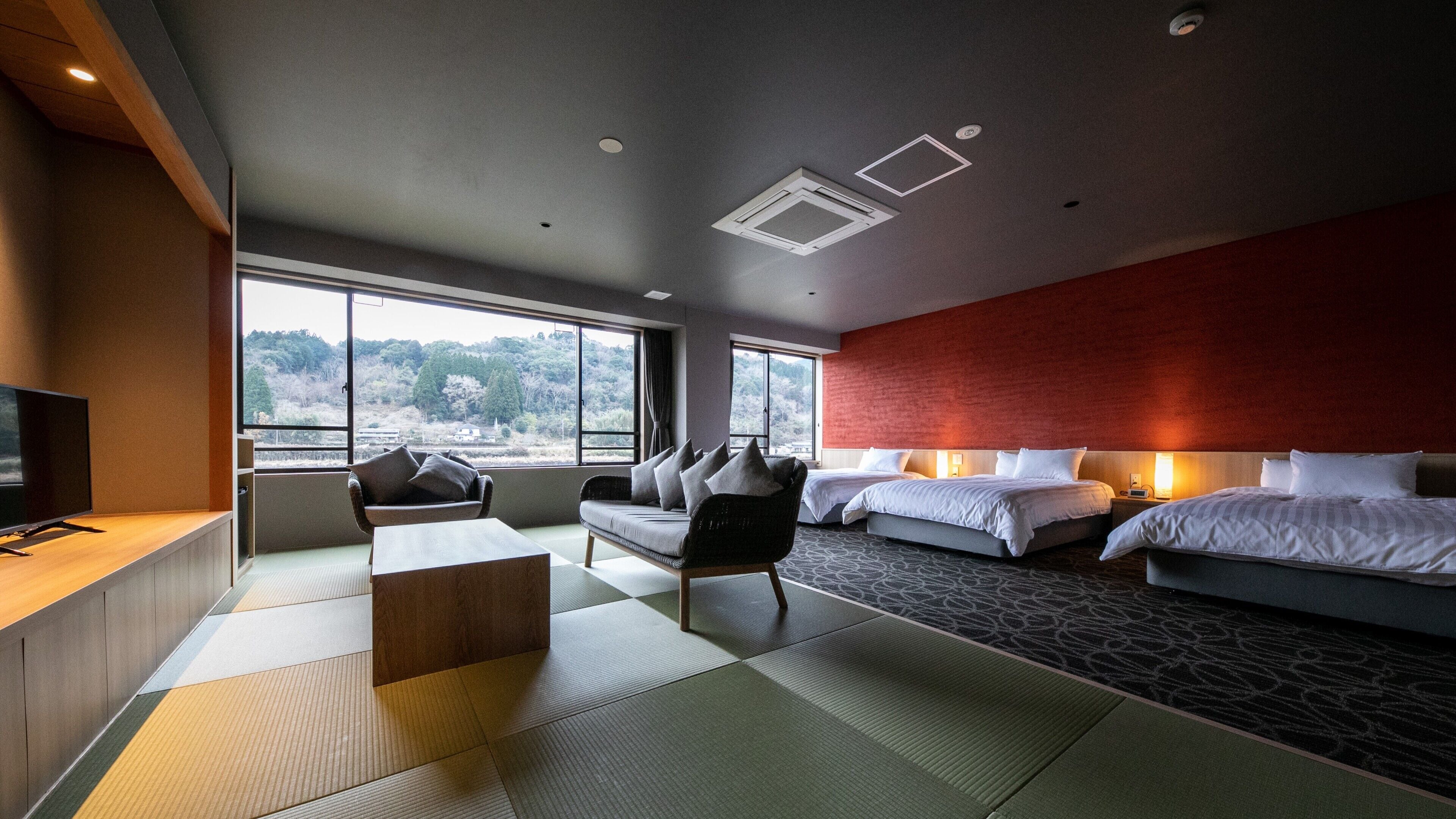 Una habitación de hotel con cama, sofá, televisor y vistas al exterior.