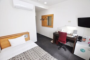A hotel room with a bed, a desk with a chair, a mirror, a television, and a small refrigerator. - Futsukaichi Green Hotel (Chikushino)