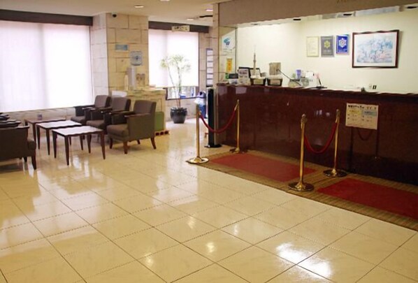 A reception area with a desk, chairs, and a red carpet leading to the entrance. - Mizue Daiichi (Tokyo)