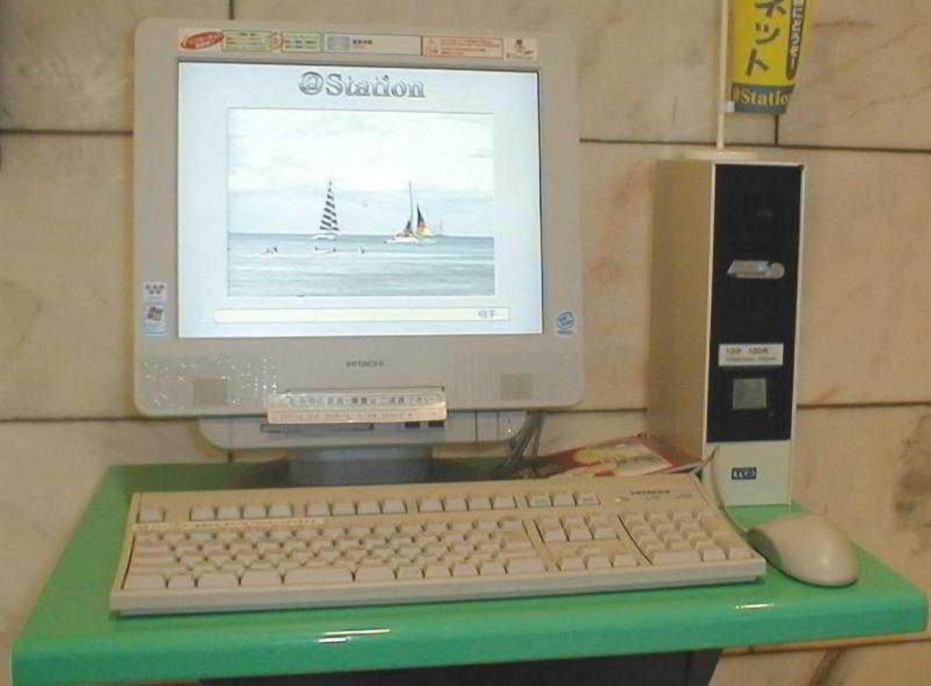 A desktop computer with a monitor, keyboard, and mouse on a green desk.