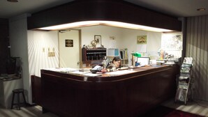 A reception desk with a computer, a telephone, and a magazine rack. - Jyonai Hotel (Karatsu)