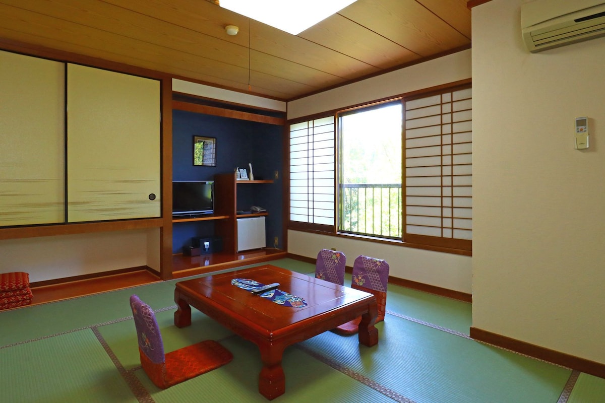 Une pièce de style japonais traditionnel, avec un sol recouvert de tatamis, une petite table en bois et des paravents en papier de riz (shoji).