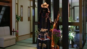 A traditional Japanese room with tatami flooring, a low table with a statue, and sliding doors. - Ryokan Satsumanosato (Satsumasendai)