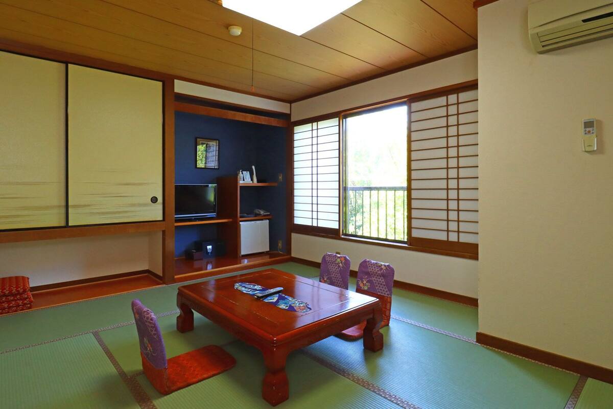 Een traditionele Japanse kamer met tatami vloerbedekking, een lage houten tafel en shoji schermen.