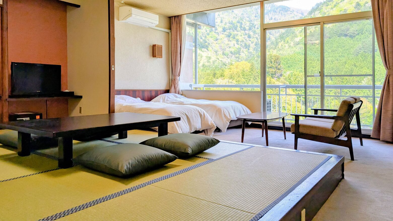 Una habitación con cama, mesa, silla y televisor.