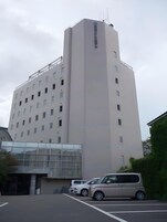 Un edificio de varios pisos con fachada plana, varias ventanas y un cartel lateral.