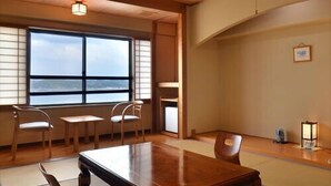 A traditional tatami room with a low table, chairs, and a view of the sea. - Hotel Shoryuen Kaisei (Kamiamakusa)