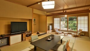 Ein traditioneller japanischer Wohnraum mit Tatami-Böden, einem niedrigen Tisch und Shoji-Bildschirmen.