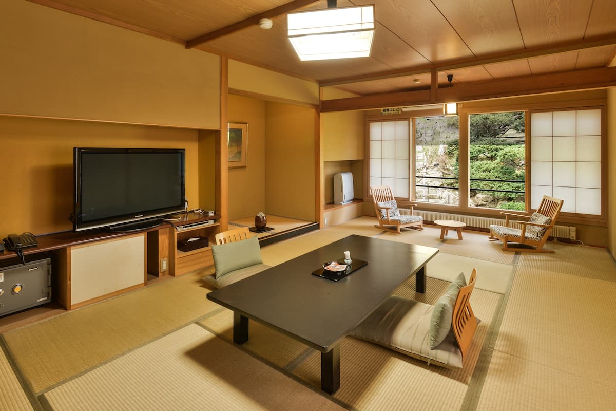 A traditional Japanese-style living room with tatami flooring, a low table, and shoji screens.
