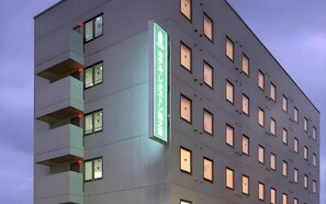 A multi-story building with a prominent vertical sign displaying text. - Hotel Lexton Tokunoshima Tokunoshima (Tokunoshima)