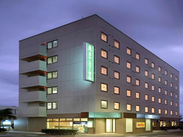 Ein mehrstöckiges Hotel mit modernem Design, mit Balkonen in den oberen Etagen und einem Restaurant im Erdgeschoss.