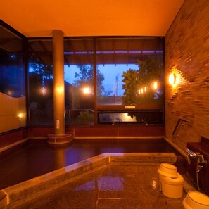 A spa room with a large window, a stone bathtub, and a wooden wall. - Choubounoyado Shiori (Beppu)