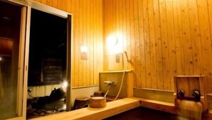 Interior de madera con un baño termal, bancos de madera y una ventana.