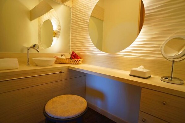 A modern bathroom with a round mirror, a sink, and a toilet. - Kusayane no Yado Ryunohige (Yufu)