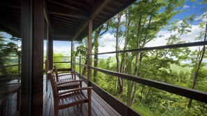 A wooden deck with benches overlooking a forested landscape.