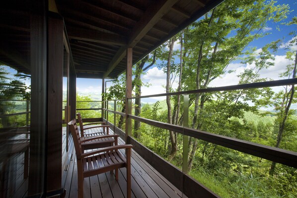 A wooden deck with benches overlooking a forested landscape. - Kusayane no Yado Ryunohige (Yufu)