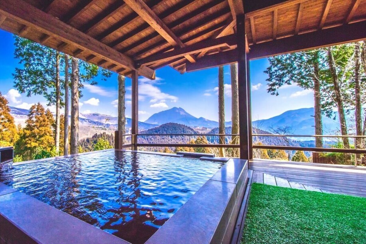 A hot tub with a wooden deck and a view of mountains.