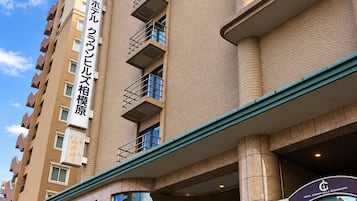 A multi-story hotel building with a prominent entrance and signage indicating it is a hotel.