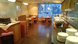 Ein Restaurant mit Holzkuben, einer Küchenzeile und Blick auf die Straße.