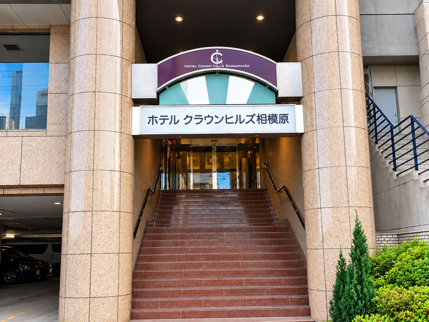 A hotel entrance with a sign indicating 'Hotel Crown Hills Saginomiya' and a staircase leading to the lobby.