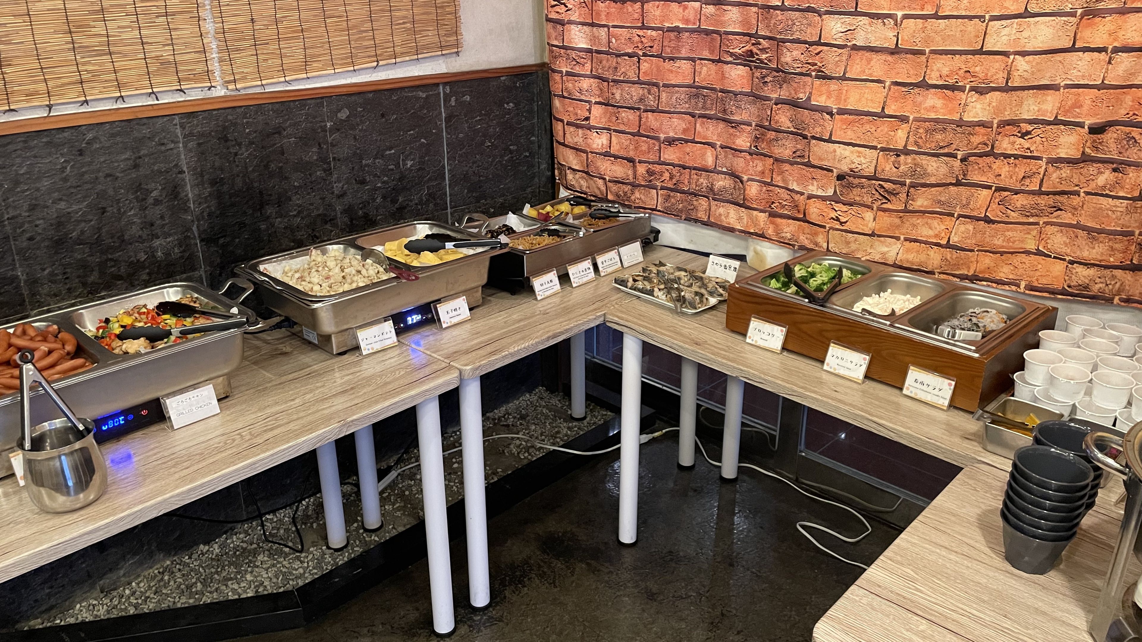 A buffet setup with various food items and serving utensils.