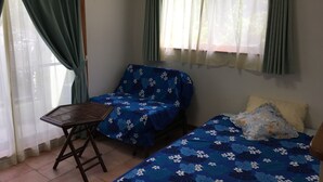 A room with two beds, a small table, and a window with curtains. - Yugafu Kabira Ishigaki (Ishigaki)