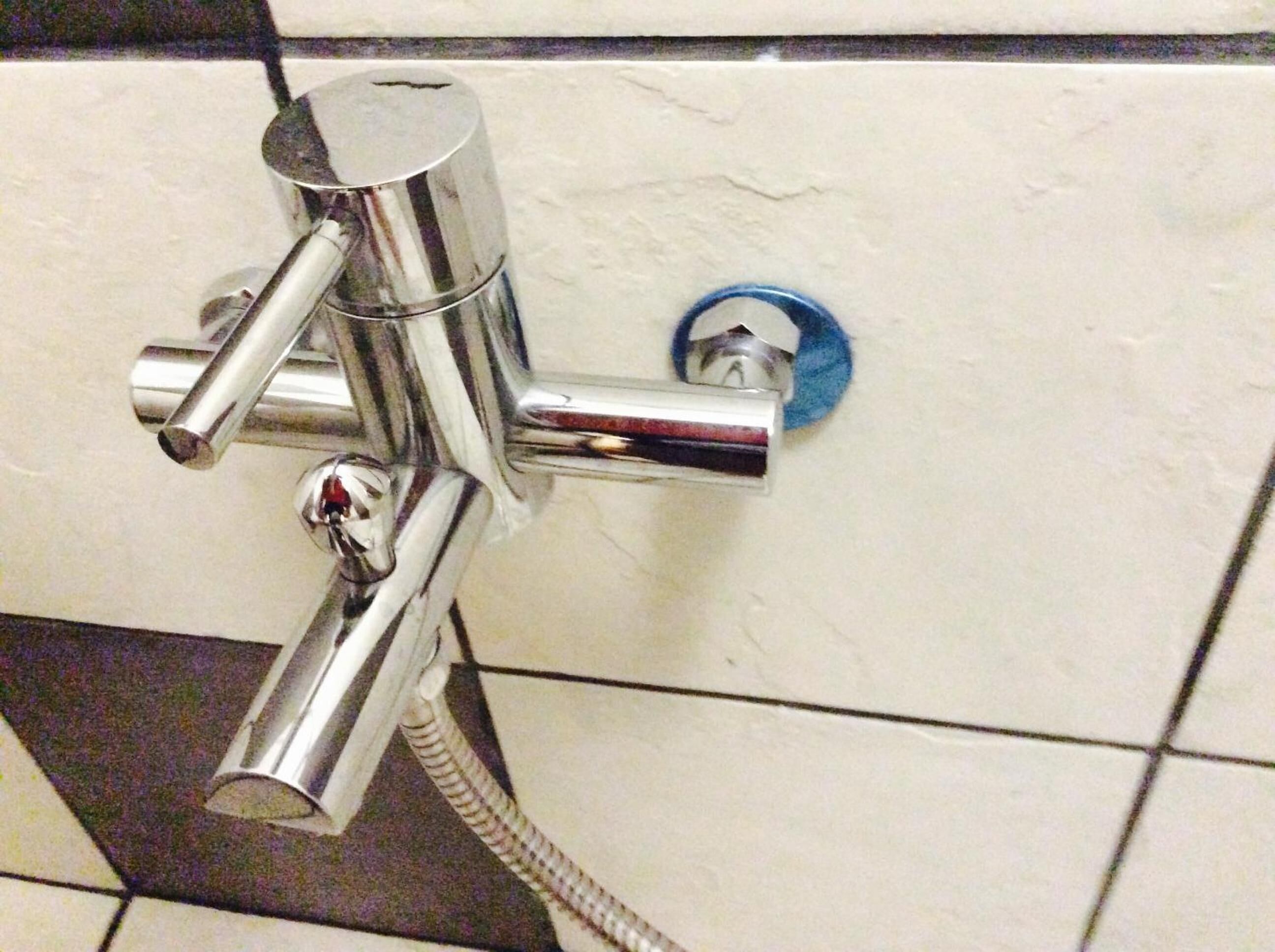 A chrome shower control with a flexible hose.